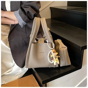 Detail of khaki lychee grain bucket bag set with pearl chain and fashion lettering