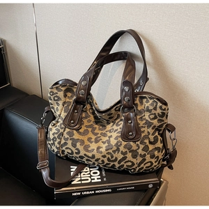 Macro detail of leopard print canvas tote with brown faux leather handles and silver rivets