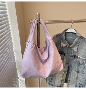Close-up of purple nylon hobo tote bag with natural wrinkled texture and resin zipper