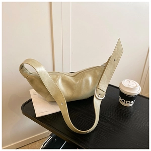 Detail of light green crescent bag with geometric stitching and silver metal hardware