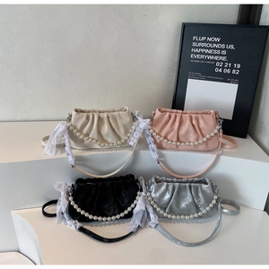 Detail of pleated cloud handbags with pearl handles and lace straps in four colors