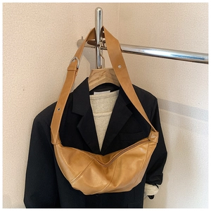 Close-up of caramel crescent bag with soft PU leather texture and adjustable strap