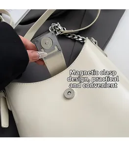 Détail macro montrant le fermoir magnétique d'un sac seau en cuir de couleur crème