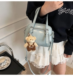 Dettaglio borsa Boston celeste lucida con finiture argento e ciondolo a orsetto