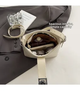 Vue intérieure d'un sac bandoulière beige montrant l'espace pour téléphone et parfum