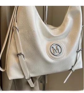 Détail du sac cabas blanc en similicuir plissé avec logo M argenté et bandoulière