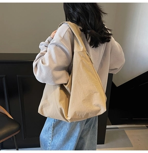 Détail du grand sac hobo beige montrant son matériau léger et sa fermeture éclair robuste
