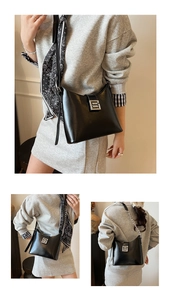 Détail du sac seau en cuir noir avec boucle métallique argentée et bandoulière chaîne