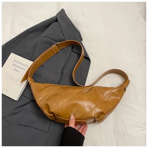 Detail view of brown dumpling bag with decorative diagonal stitching and adjustable strap