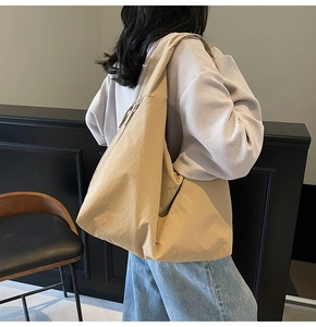 Detail of khaki canvas tote bag with wide shoulder strap and metal zipper closure