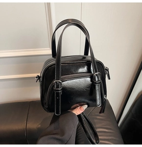 Dettaglio della borsa bowling nera lucida in pelle testurizzata con finiture argento