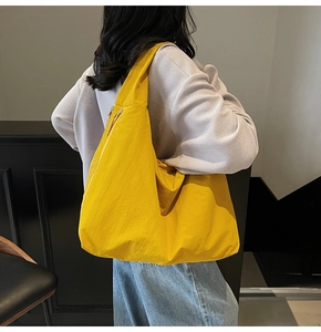 Detail of bright yellow canvas tote bag featuring large capacity and side metal zipper