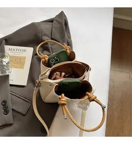 Detail view of the interior compartments and zip pocket of a cream PU bucket bag