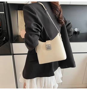 Dettaglio di una borsa hobo in pelle crema con chiusura a G argentata sulla spalla