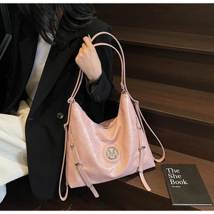Détail du cabas rose en cuir verni brillant avec logo M et boucles de sangle décoratives