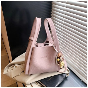 Close-up of pink litchi grain leather tote bag with pearl chain and fashion pendant