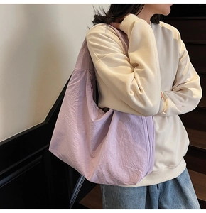 Close-up of a large lavender purple tote bag featuring textured fabric and wide shoulder strap