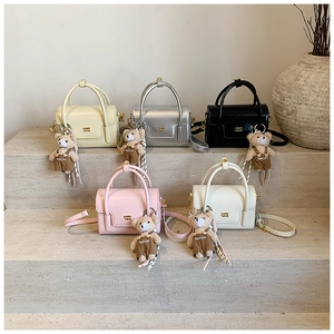 Close-up of five mini flap handbags in various colors with cute plush bear charms