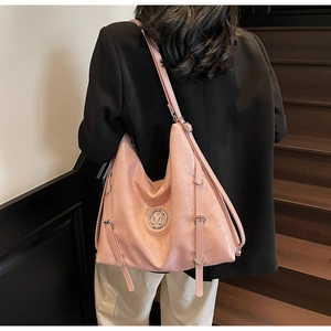 Détail du sac cabas rose brillant avec logo M métallique et bandoulière réglable