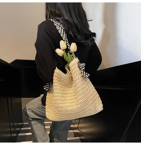 Détail du sac cabas en paille tissé à la main avec texture ajourée et bandoulière rayée
