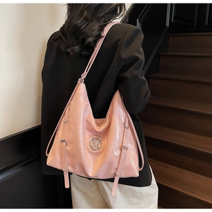 Vue détaillée du sac cabas rose brillant avec logo M en métal et boucles décoratives