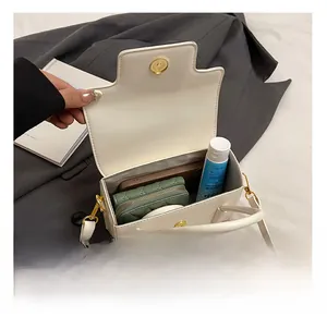 Detail view of white leather handbag interior showing storage for phone and wallet
