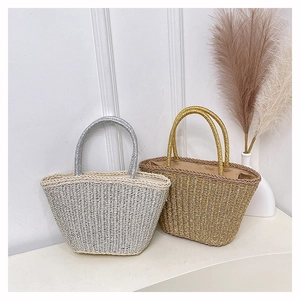 Détail de sacs à main en paille tressée argentée et dorée avec poignées métalliques brillantes