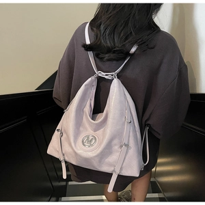 Détail du sac à dos en similicuir lilas avec logo M et bretelles réglables