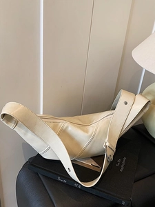 Creamy leather crescent bag with adjustable wide strap and vintage metal hardware