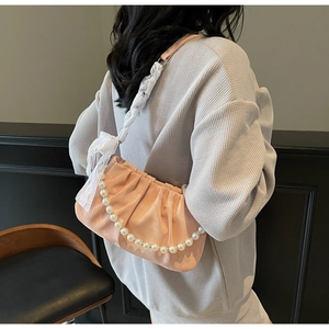 Pink pleated cloud bag detail with large pearl chain and elegant white lace ribbon decoration