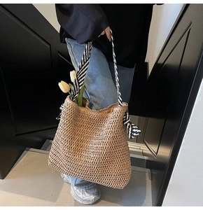 Détail du sac cabas en paille avec poignée ruban rayé noir et blanc pour look plage