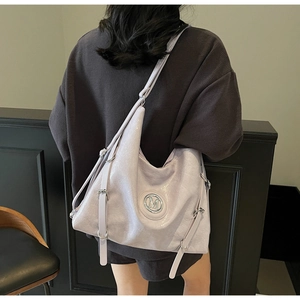 Détail du sac cabas en cuir verni lavande brillant avec logo M métallique élégant
