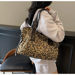 Detail of leopard jacquard tote bag with dark brown leather handles and silver hardware
