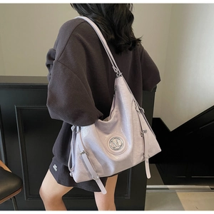 Détail du grand sac hobo lilas en cuir PU avec logo M métallique et bandoulière réglable
