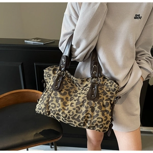 Detail of leopard print tote bag featuring leather stitching and metal rivets reinforcement
