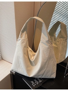 Minimalist beige oversized canvas tote bag with double zipper and wide shoulder strap