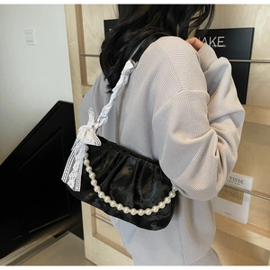 Black ruched cloud bag featuring elegant pearl chain strap and a white lace bow detail