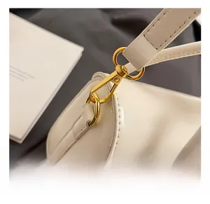 Macro shot of premium golden alloy swivel hook and white leather strap connector details