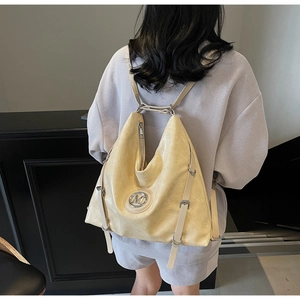 Vue de dos d'un mannequin portant le sac à dos polyvalent jaune clair brillant avec logo M