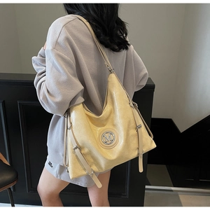 Détail d'un grand sac fourre-tout crème à texture froissée brillante et logo M argenté