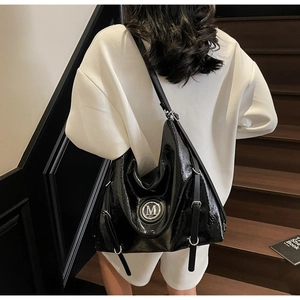 Détail du sac Hobo en cuir verni noir brillant avec logo M argenté et boucles métalliques