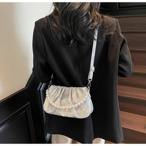 Detail of silver gray pleated cloud bag with pearl chain and metallic fabric texture