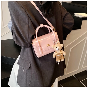 Rosa glänzende Mini-Handtasche an der Schulter mit niedlichem Bären-Anhänger und Logo