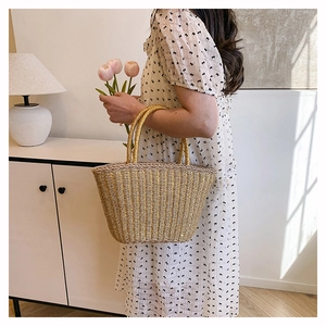 Detail of hand-woven straw tote bag with round handles for a vacation beach aesthetic