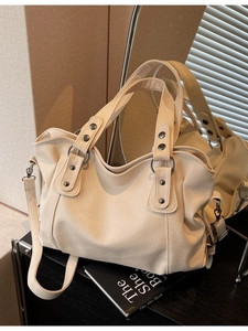 Cream textured PU leather tote bag with silver hardware and detachable strap shown in lifestyle setting