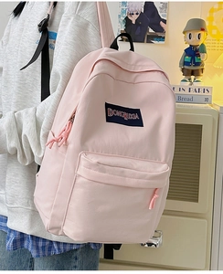 Primer plano de mochila ligera rosa claro de nailon resistente con asa superior negra