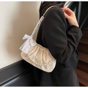 Detail of white satin cloud bag with pearl chain and elegant lace bow detail