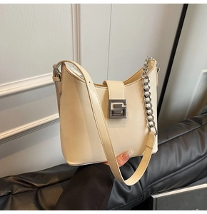 Détail du sac crème avec une chaîne en argent et une boucle métallique en forme de G
