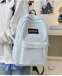 Detalle del amplio bolsillo frontal y la etiqueta tejida en una mochila escolar azul