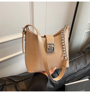 Détail du sac à bandoulière beige avec boucle argentée G et lanière en chaîne